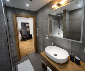 ein Badezimmer mit einem weißen Waschbecken und einem Spiegel in der Unterkunft Landhaus Ambachhof in Oetz