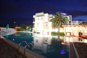 a swimming pool in front of a building at night at Hotel Acquario in Campomarino +30 photos