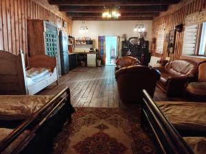a living room with couches and chairs and a kitchen at Gypsy Camp Apartments & Glamping in Liepāja