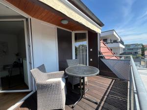 a patio with a table and chairs on a balcony at Ferienwohnung Bodenseeparadies in Friedrichshafen