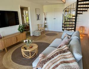 a living room with a blue couch and a table at Mt Martha - Mar Vista - Panorama views with Modern coastal style in Mount Martha