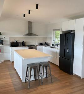 a kitchen with a counter and a black refrigerator at Mt Martha - Mar Vista - Panorama views with Modern coastal style in Mount Martha