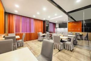 大同JinJiang Inn Datong Pingchengqiao的配有桌椅和屏幕的会议室