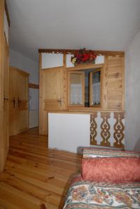 salon z kanapą i oknem oraz drewnianą podłogą w obiekcie La Coquille Apartment w mieście Breuil-Cervinia