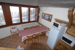 kuchnia ze stołem, krzesłami i kuchenką mikrofalową w obiekcie La Coquille Apartment w mieście Breuil-Cervinia