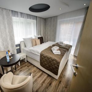 ein Schlafzimmer mit einem Bett, einem Tisch und einem Stuhl in der Unterkunft Landhaus Ambachhof in Oetz