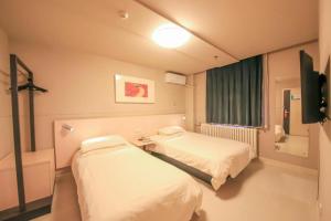 a hospital room with two beds and a television at Jinjiang Inn Ulanqab Jining 1st Middle School in Ulanqab