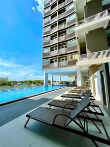 a row of lounge chairs on the balcony of a building at Cozy & Homey 3-Bedroom in Iloilo City