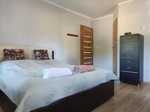 a bedroom with a bed with two pillows and a dresser at Pokoje gościnne Cyraneczka in Lądek-Zdrój