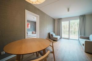 a living room with a table and a couch at NA WYDMIE Apartments&Camp in Dziwnówek