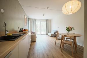 a kitchen with a table and a dining room at NA WYDMIE Apartments&Camp in Dziwnówek