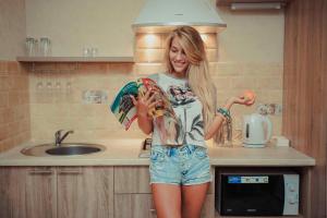 a woman standing in a kitchen with a bowl of food at Molex Apartments 2 in Chernihiv