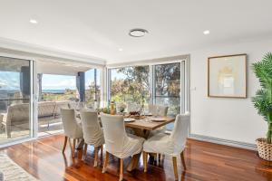 a dining room with a table and chairs at Diamond Head Manor - Pool, Water Views, Central in Budgewoi