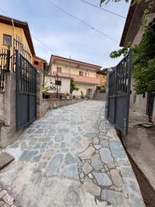 an alley with two gates and a stone walkway at Vila Du Lac Blue in Pogradec