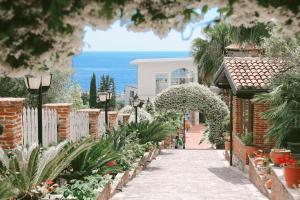 a walkway leading to a house with a garden at Hotel Sarajet e Pashait 1 in Dhërmi