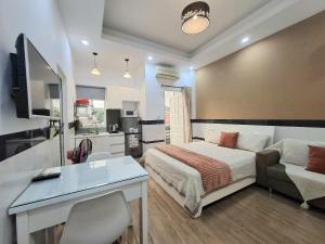 una camera da letto con un letto, una scrivania e un divano di Saigon Apartments 2 ad Ho Chi Minh