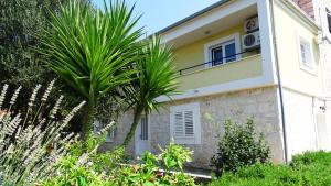 uma casa com uma palmeira em frente em Seaside Villa Mia Trogir em Trogir