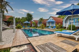 una piscina con banco y sombrilla en Megaland Bungalow, en Nusa Penida