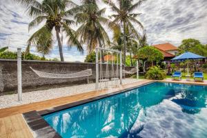 una piscina con una hamaca y palmeras en Megaland Bungalow, en Nusa Penida 9 fotos más