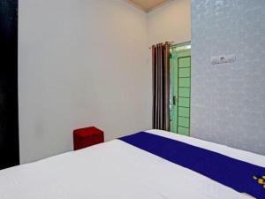 a bedroom with a white bed and a green door at OYO Life 91323 Omah Victoria Homestay & Culinary in Wonogiri