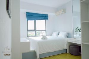 Un dormitorio con una cama blanca con una ventana. en Masteri Thao Dien Apartment Complex, en Kon Rung (1) 92 fotos más