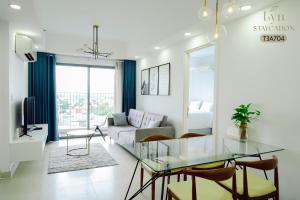 Una sala de estar con una mesa de cristal y un sofá. en Masteri Thao Dien Apartment Complex, en Kon Rung (1)
