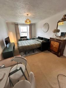 a bedroom with a bed and a clock on the wall at One bed Apartment with Parking in Seaford