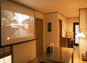 a living room with a large projection screen on the wall at 如意二条城Ruyi Nijojo in Kyoto