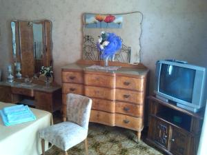 a bedroom with a dresser and a tv and a chair at Nice House wifi free bici free in Avola