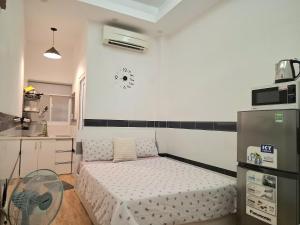 una piccola camera con letto e frigorifero di Saigon Apartments 2 ad Ho Chi Minh