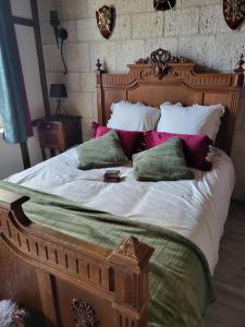 a bedroom with a large wooden bed with pillows at Maison Médiévale LAON in Laon