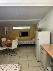 a kitchen and dining room with a table and a refrigerator at B&B Le Tre Gemme in Lentini +8 photos
