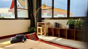 1 dormitorio con 1 cama y 1 habitación con ventanas en Baan PadSeeEw - Rooftop Riverview 4th floor, en Thonhuri