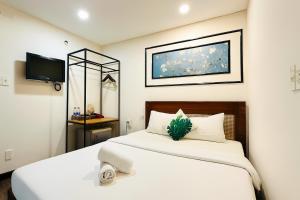 a bedroom with two white beds and a tv at Vintage Park View Hotel & Spa - Hoang Phi in Ho Chi Minh City