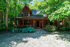 een houten huis met een veranda en een tuin bij Cedarwood Lodge in Saugatuck