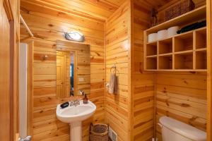 a bathroom with wooden walls and a sink and a toilet at Cedarwood Lodge Community Pool! in Saugatuck +20 photos