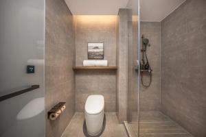 Atour Hotel Wuhan Hankou Riverside Park, Jiefang Avenue في Jiang'an: حمام مع مرحاض ودش