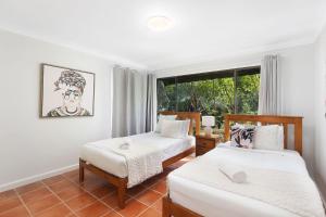 a bedroom with two beds and a window at Lakeside Escape steps To The Lake and Beach in Long Jetty