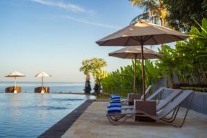 Lovina Beach Club & Resort في لوفينا: زوج من الكراسي ومظلة بجانب مسبح +52 صورة