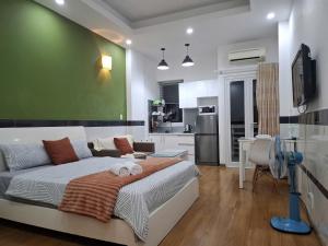 un soggiorno con letto e parete verde di Saigon Apartments 2 ad Ho Chi Minh