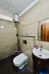 a bathroom with a toilet and a sink at Cozy 1 RK apartment in Indore