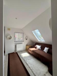 a attic bedroom with two beds and a window at Villa Viktória in Lunca de Sus