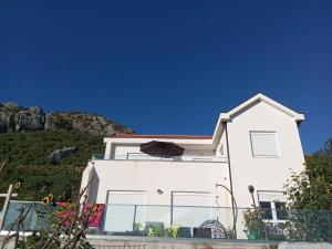 a white house with a hill in the background at Lapčiči View in Budva