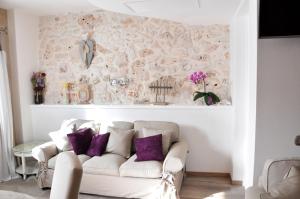 a living room with a white couch and purple pillows at Una Perla Nel Verde in Putignano