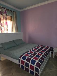 a bedroom with a bed in a room with a window at Serenity homes in Mukono
