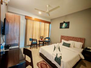 a bedroom with a bed and a table and chairs at Sylhet Paradise Inn in Sylhet