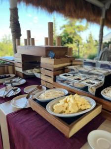 a buffet with plates of food on a table at Hotel Sarajet e Pashait 1 in Dhërmi