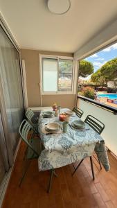 una mesa y sillas en una habitación con balcón en Ondine, en Gruissan