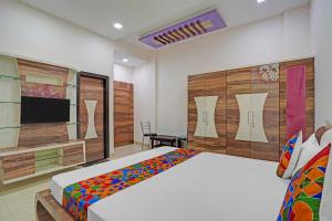 a bedroom with a bed and a flat screen tv at FabExpress Kaveri Executive - Nr Alandi vithoba temple in Pune