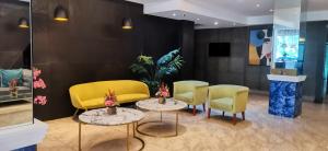 una sala de espera con sillas y mesas amarillas en Dancenter Luxury Retreat Angeles City Pampanga Formerly Hevea Resort, en Ángeles